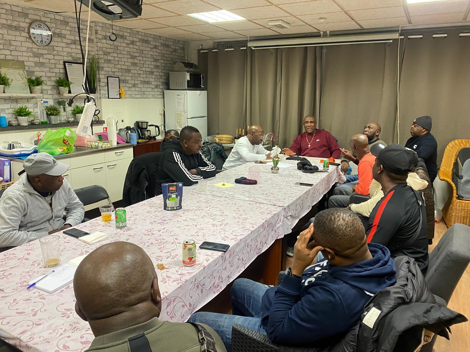 Groep leden van Stichting Maawina in gesprek rond de tafel